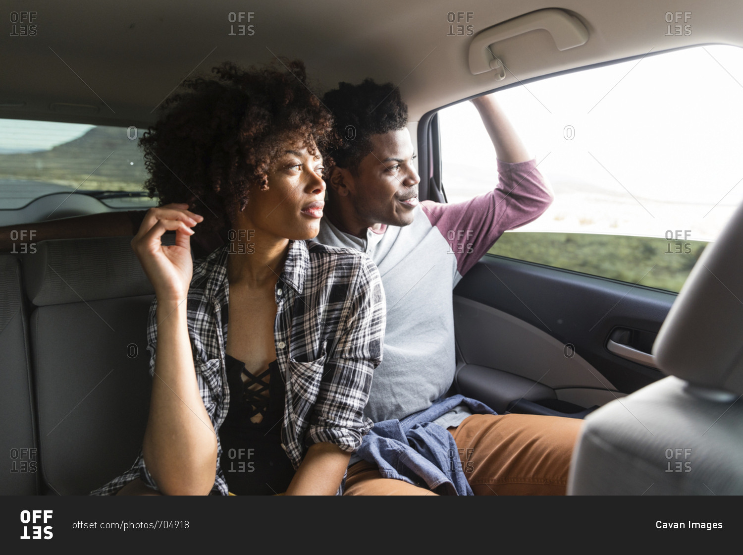 Couple looking through window while traveling in car