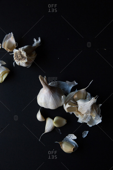 Overhead view of garlic bulbs and cloves on black background