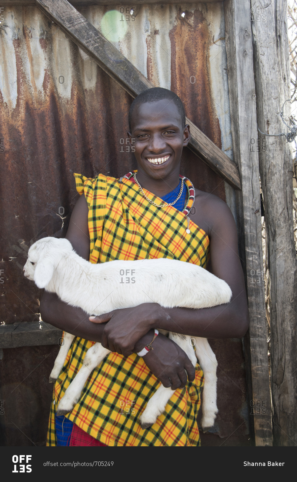 Maasai villager holding a baby goat at Maasai Mara in Kenya