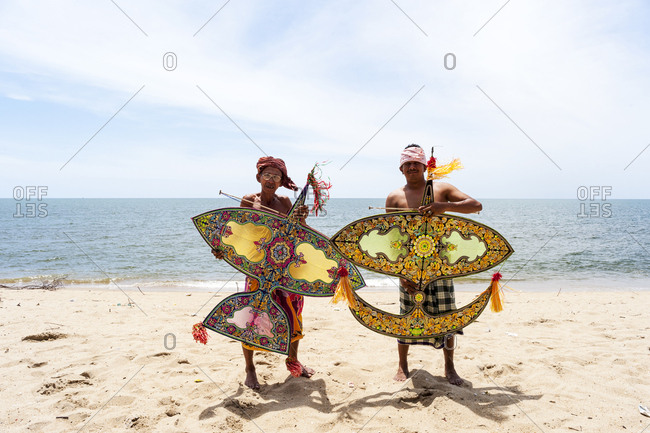 Khota Bharu, Malaysia - July 10, 2012: Two kite flyers posing on sunny beach in Malaysia