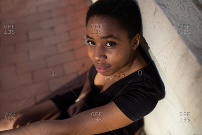Portrait of a young adult woman leaning against a wall