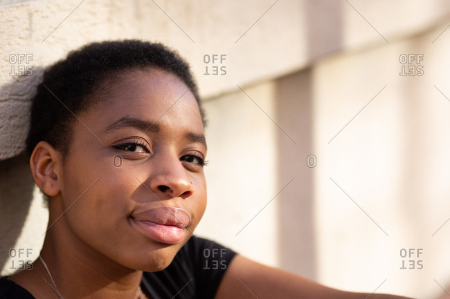 Portrait of young adult woman against wall