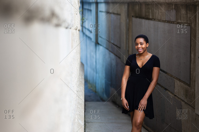 Smiling young adult woman standing in urban area
