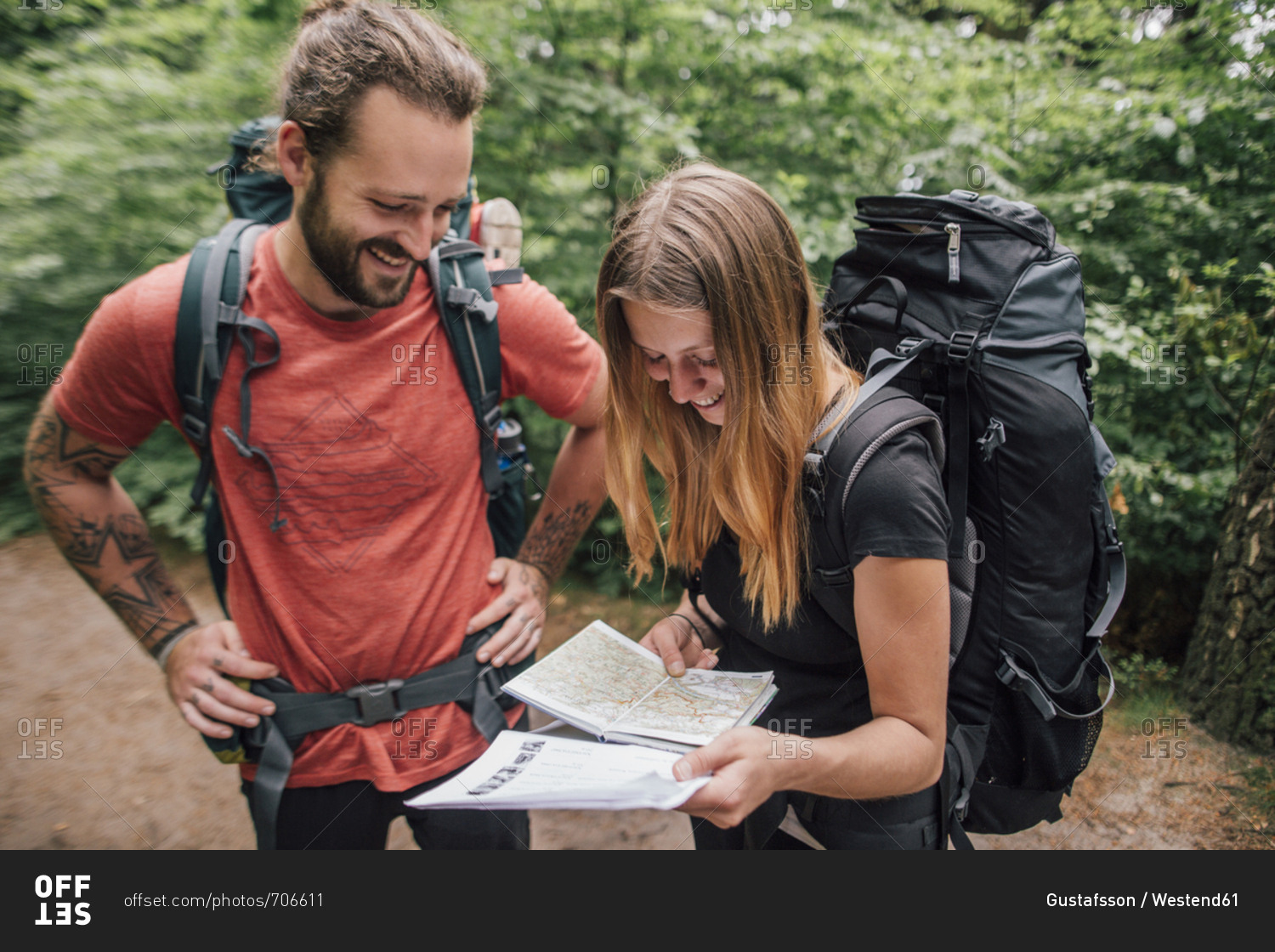 Happy young couple on a hiking trip reading map