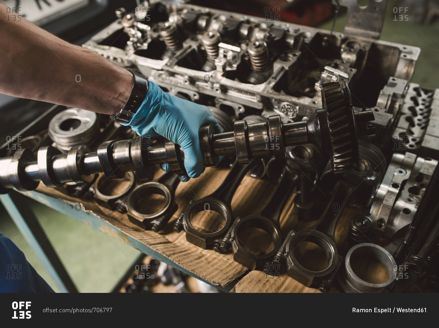 Close-up of mechanic holding the crankshaft of the engine of a car in a workshop