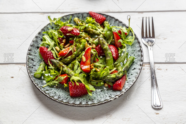 Salad of green asparagus- rocket- strawberries and pine nuts