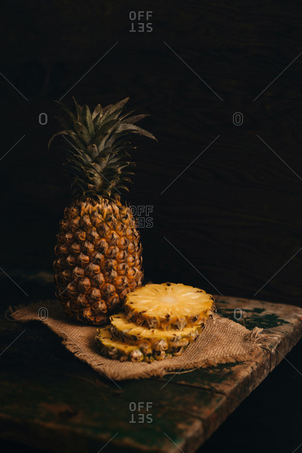Cutting fresh pineapple on wooden table