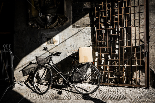 Bicycle parked in an alley with a cardboard box