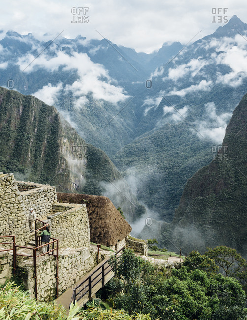 Machu Picchu, Peru - November 20, 2017: Tourism walking up stone steps in Andes mountains
