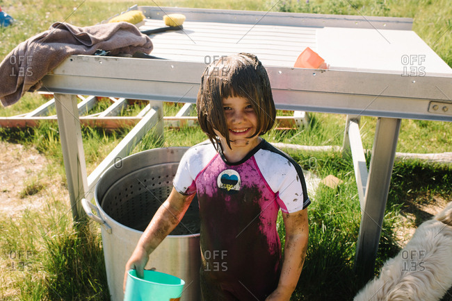 Little girl wearing muddy wetsuit