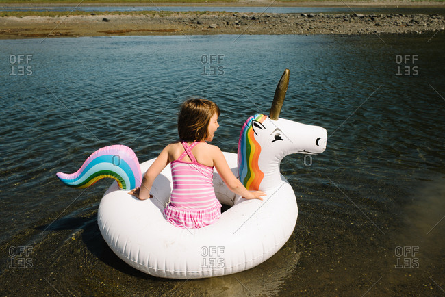 Little girl floating on a unicorn raft