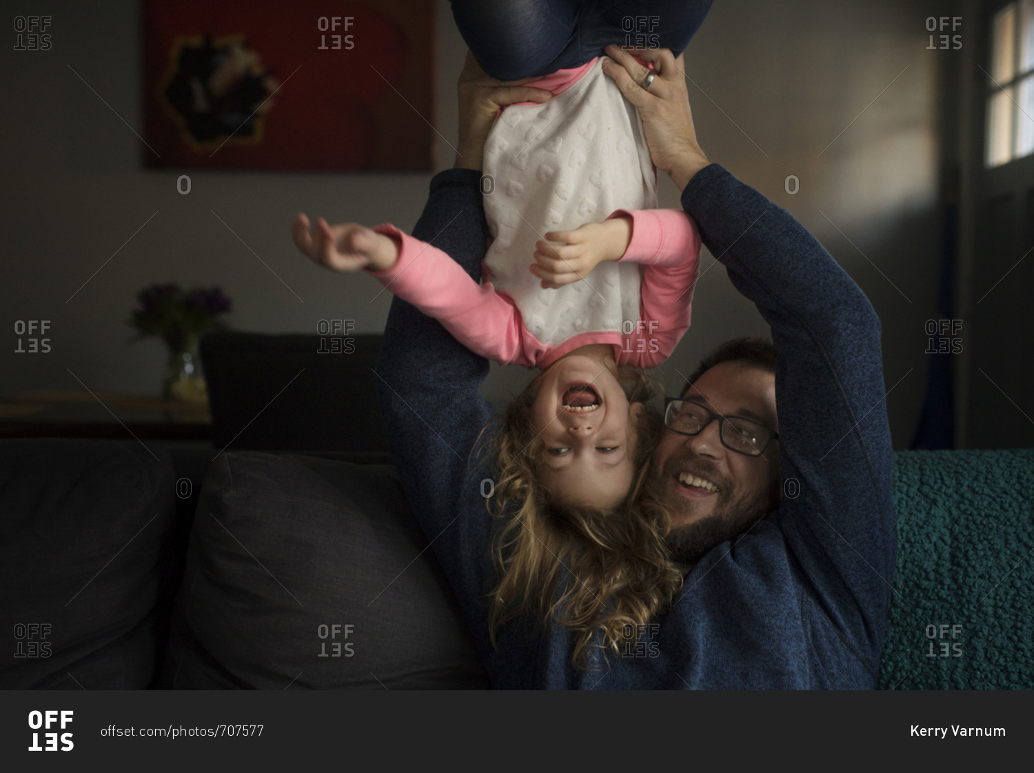 Father holding his laughing daughter upside down
