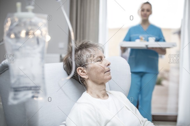 Premium Photo  Iv drip chamber and iv bag of solution with patient on bed  blurd background in patient room hospital