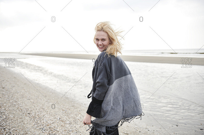 Portrait of laughing blond woman wearing knit pullover and panties