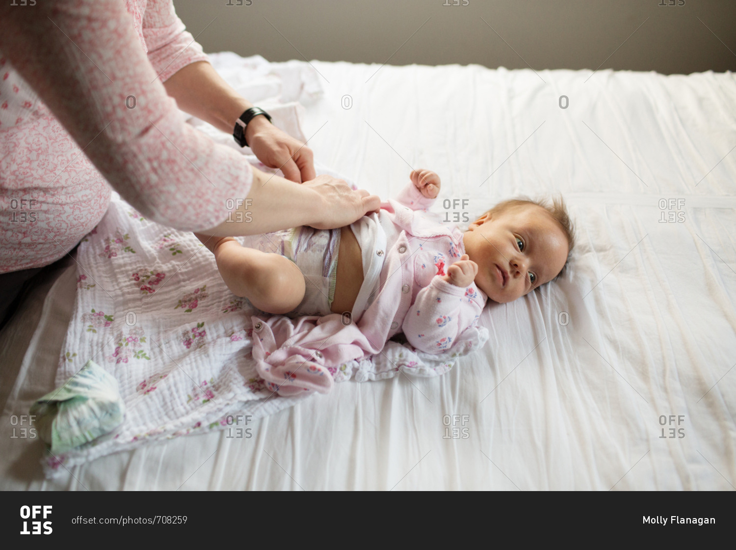 Looking down on baby having diaper changed by mother