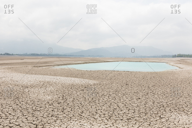 Small pool of water in otherwise arid lake bed of Forggensee in Germany