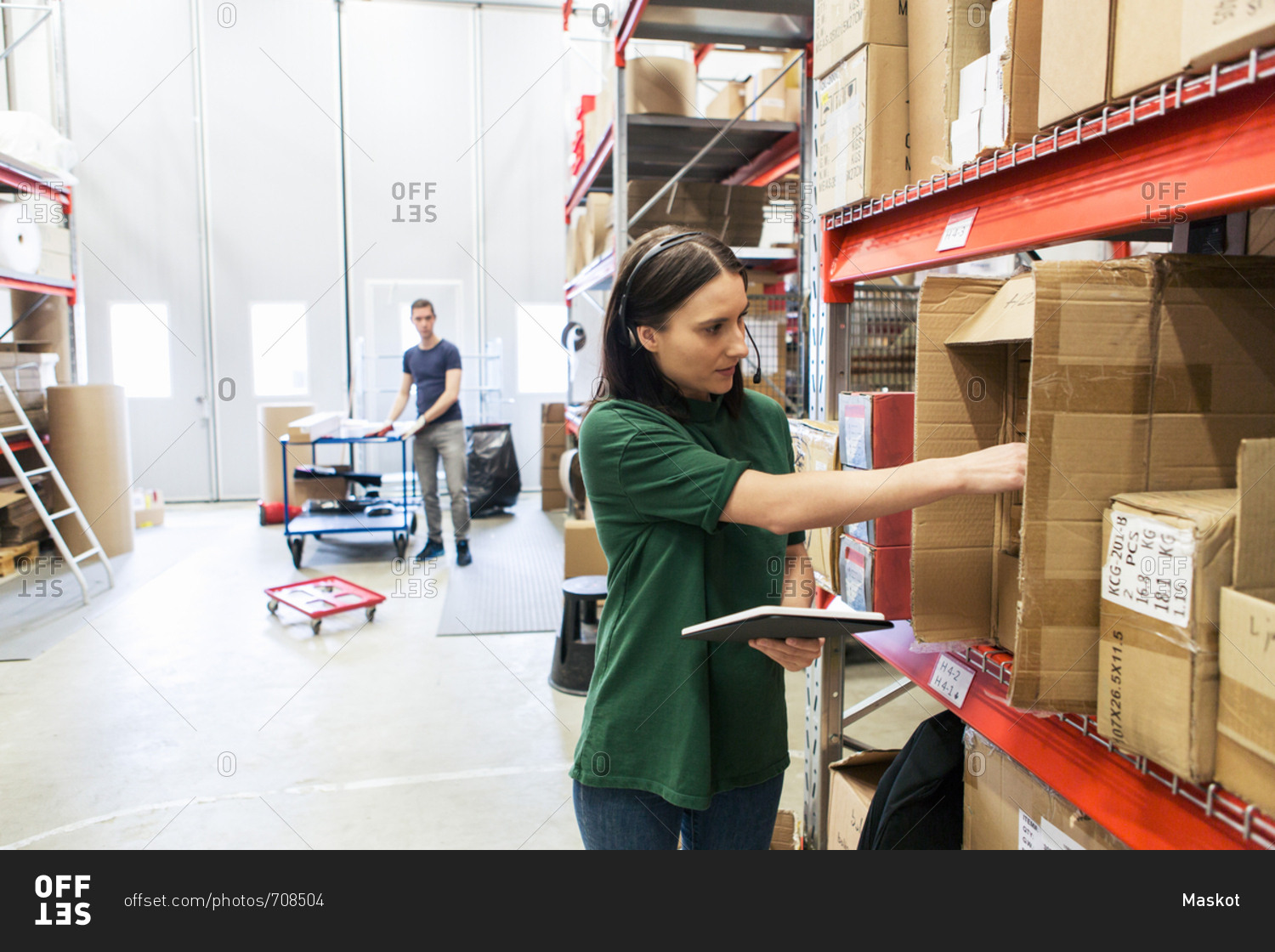 Male and female colleagues examining boxes in industry