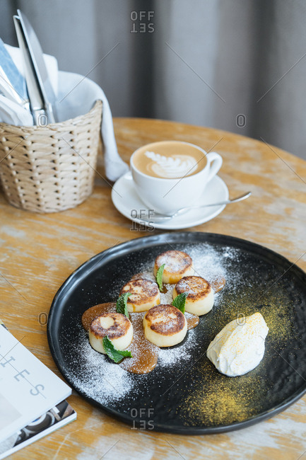 Fried custard with caramel sauce served with a latte