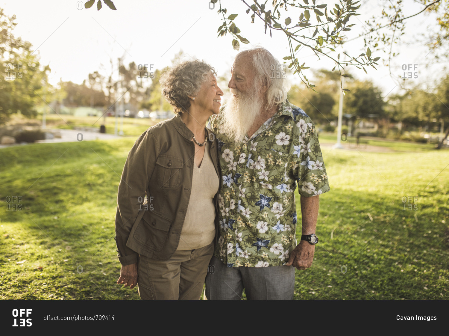 Loving senior couple looking each other face to face while standing at park