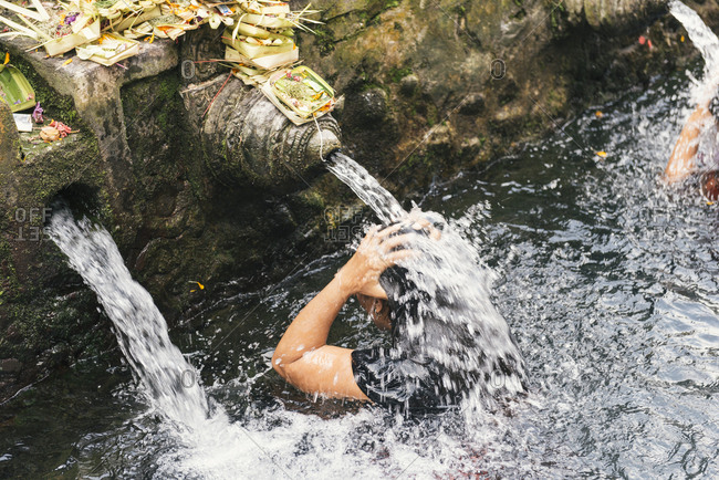 Young woman bathing in the waters of the Tirta Empul Water Temple, Ubud, Bali