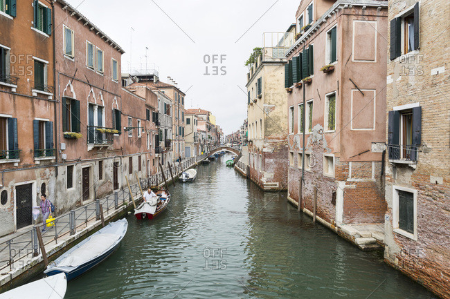 Venice, Italy - May 13, 2018: Quiet morning on a side canal with covered boats