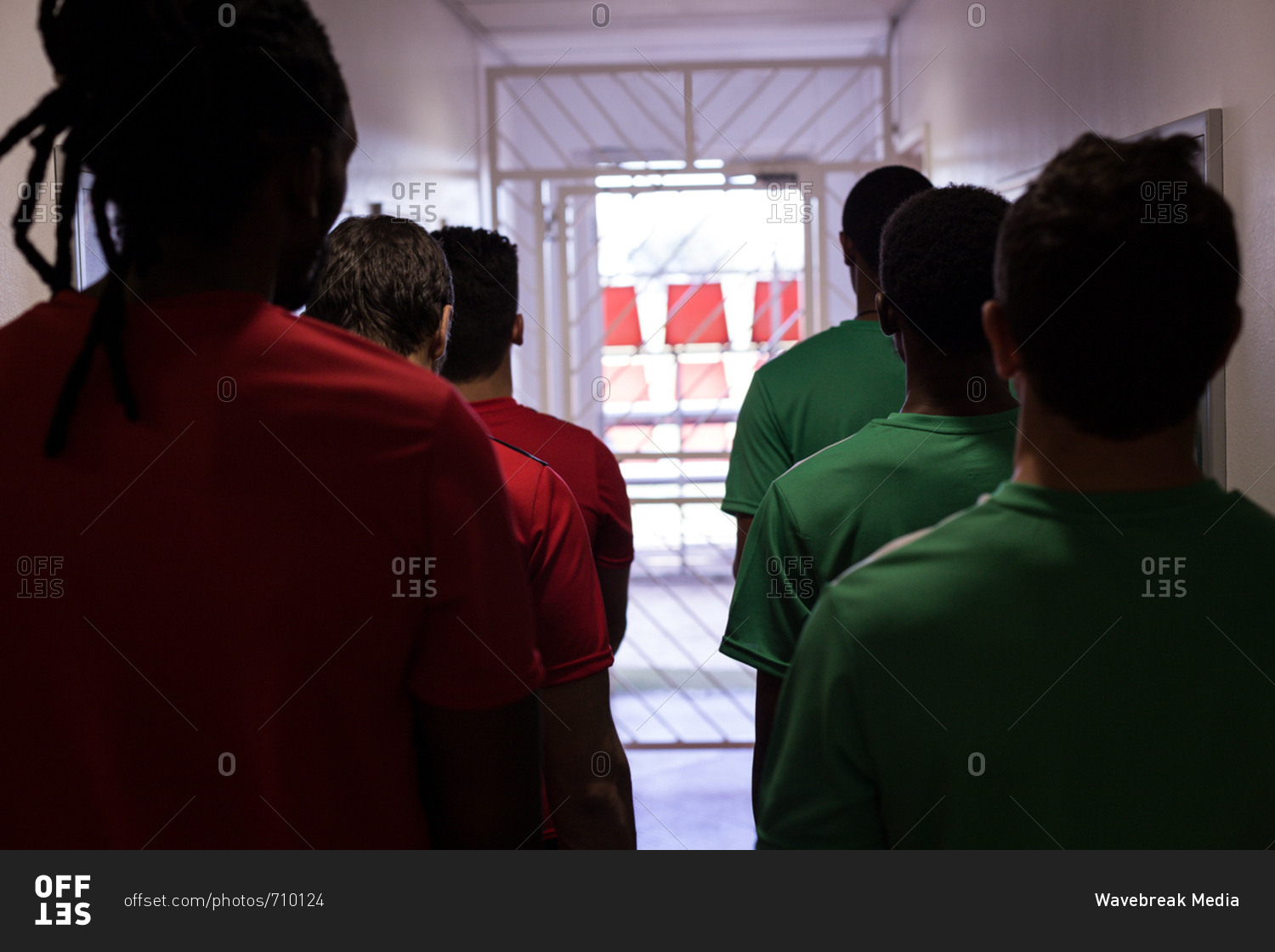 Rear view of football players leaving the dressing room