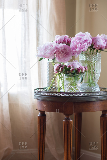 Pink peonies in glass vases on a marble table