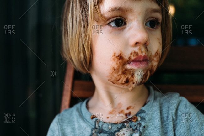 Little girl with a messy face after eating an ice cream cone