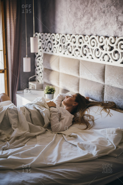 Young Woman Sprawled Out On Asleep On Large Bed In Hotel