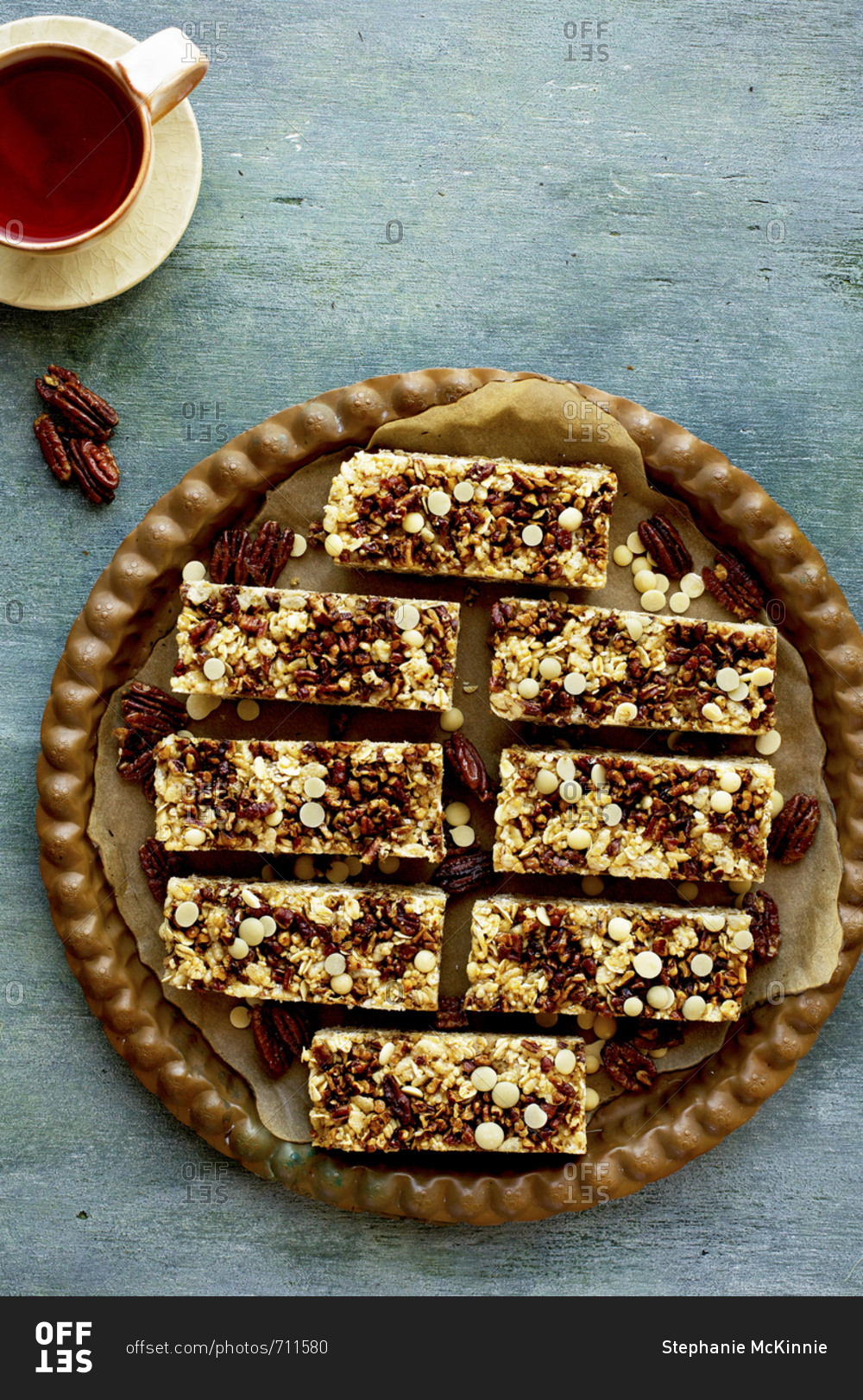 Freshly baked pecan white chocolate breakfast bars served with a cup of tea