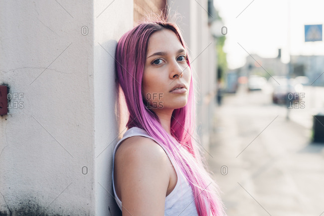 Portrait, young woman outdoor pink hair posing and looking at camera