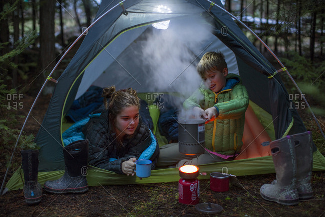Two kids boiling water while camping, Sandpoint, Idaho, USA