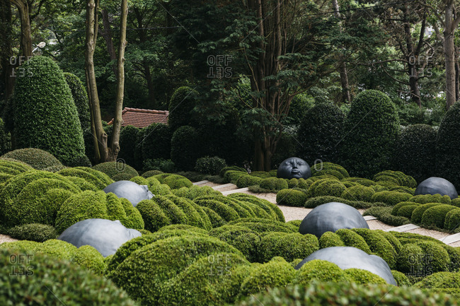 Etretat, Normandy, France - May 30, 2018: Round face sculptures in a garden in Les Jardins D'Etretat