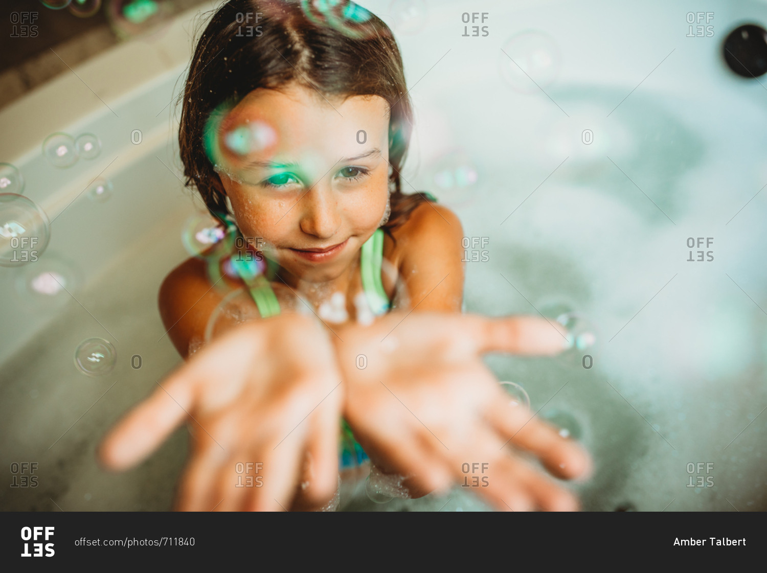 Young girl playing with bubbles in bath tub stock photo OFFSET