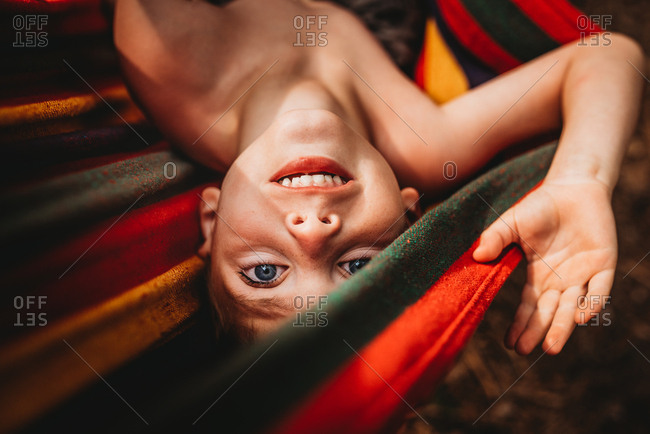 Upside down portrait of young boy in hammock