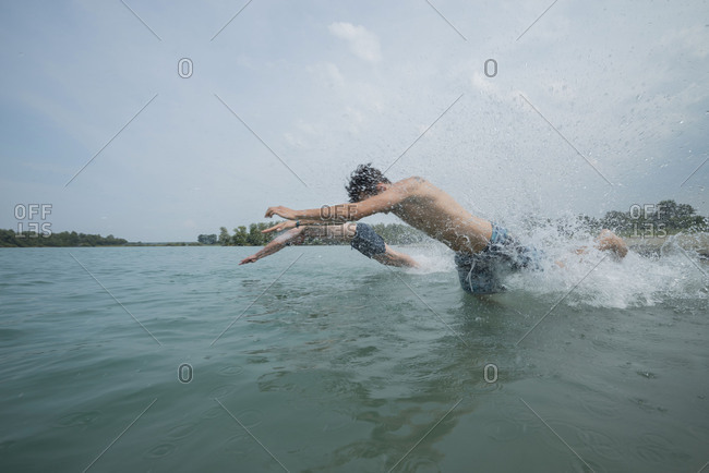 Youths while bathing in the lake, quarry pond Liedolsheim, Dettenheim, Baden-Wurttemberg, Germany