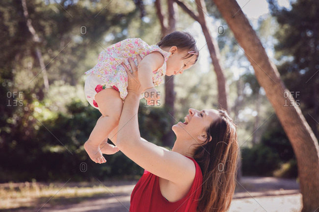 Mother lifting baby girl into the air