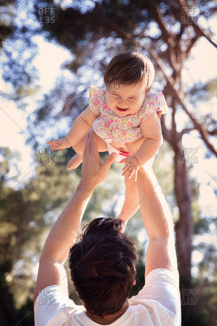 Father lifting baby girl into the air