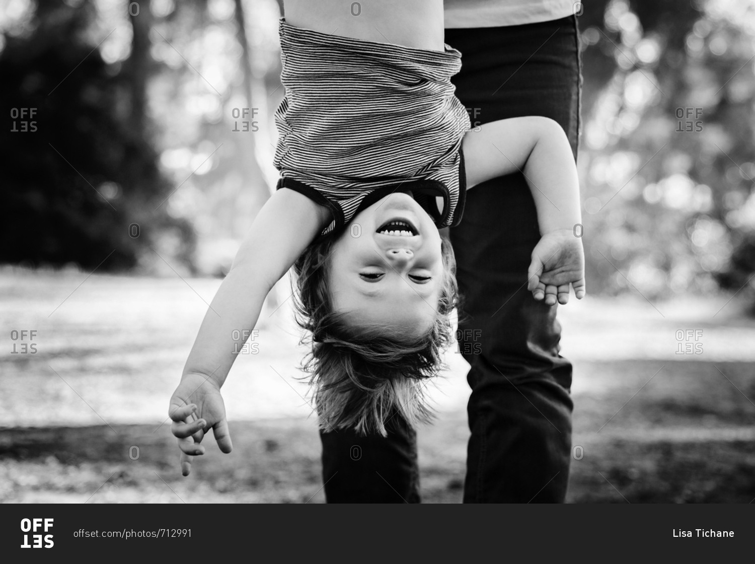 Father holding son upside down in black and white