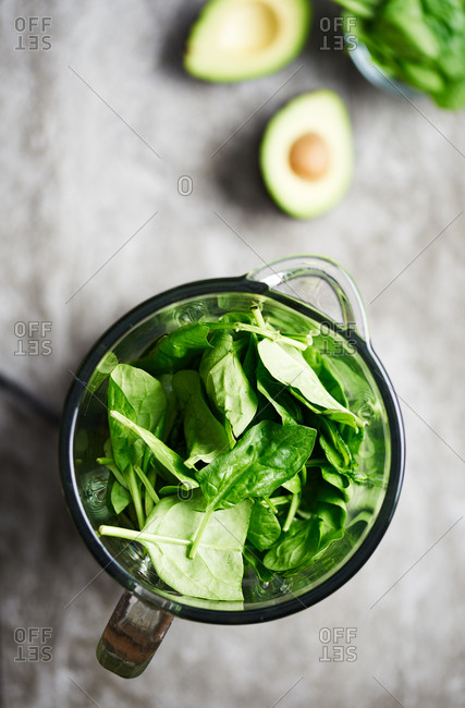 Making a healthy green spinach smoothie in a blender
