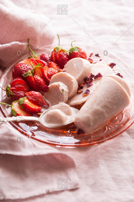 Close up of melting Indian kulfi served with fresh strawberries