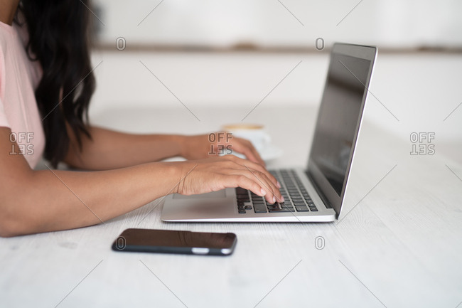 Close up of a woman typing on a laptop