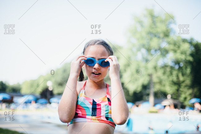 Girl drying off from pool swim in goggles