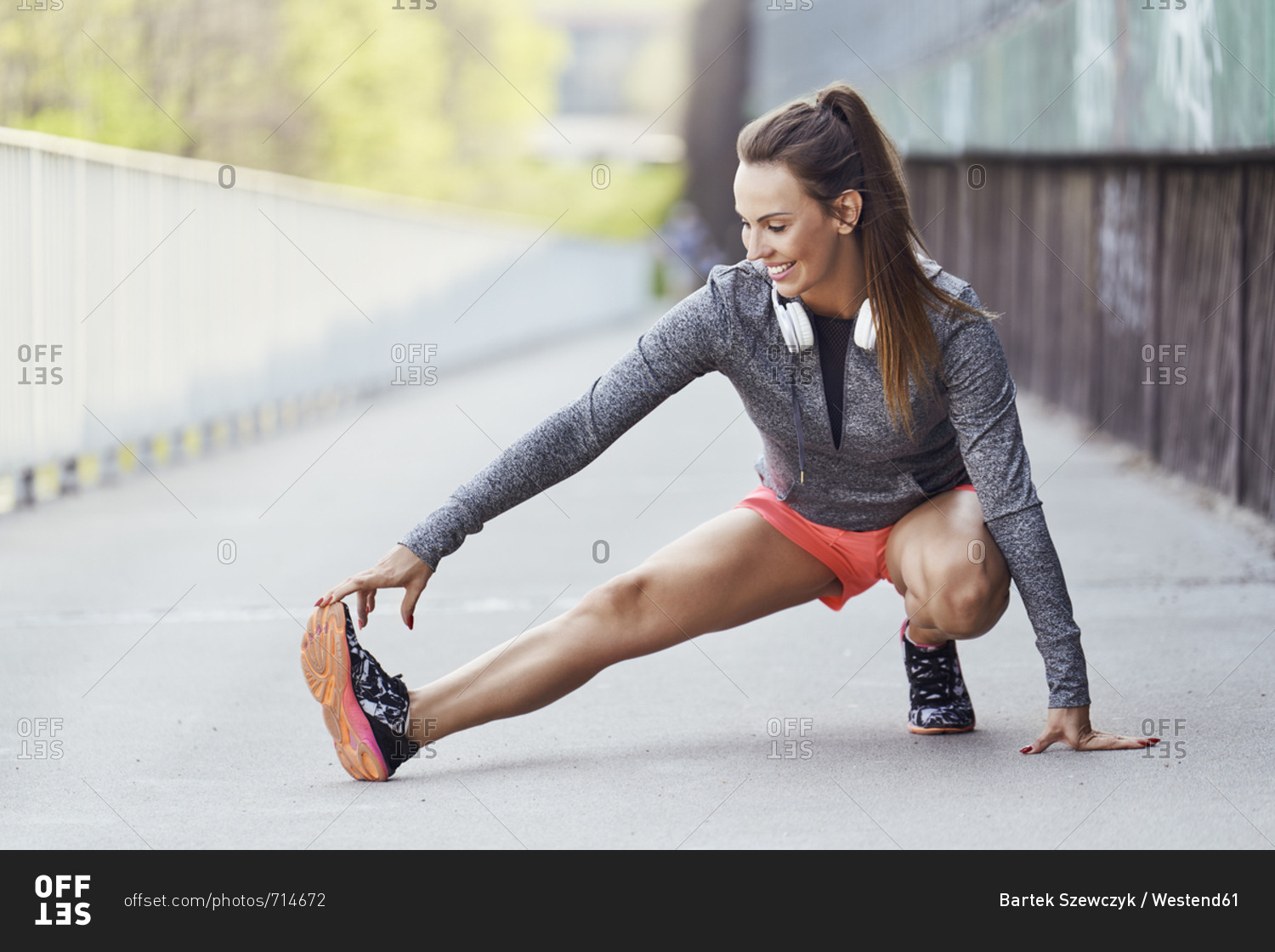 Female runner stretching legs during urban workout
