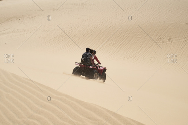 Tour guide driving red squad with tourists at the white sand dunes in Mui Ne