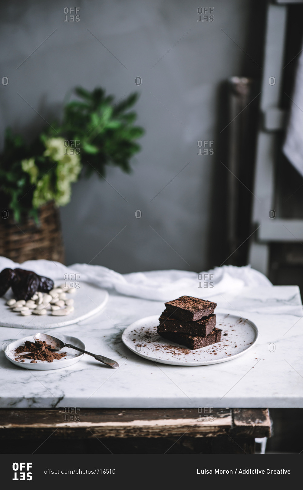 Tasty sweet vegan brownie dessert and cocoa powder on plate on a table.