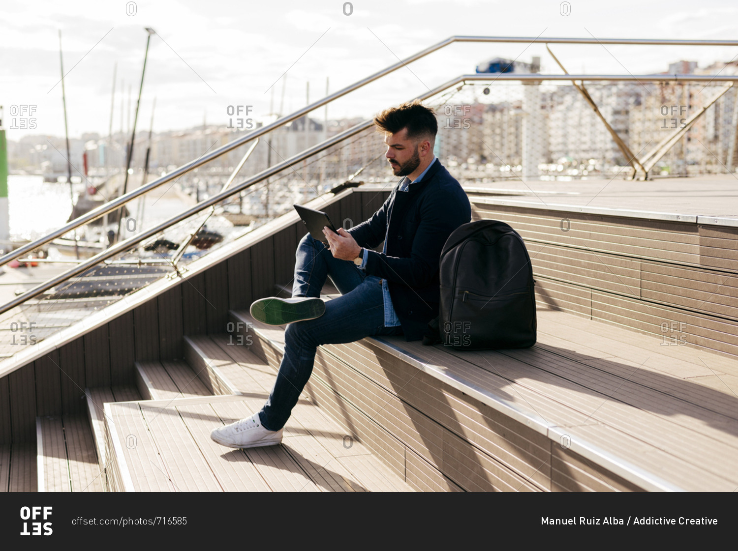 Stylish man using tablet in port