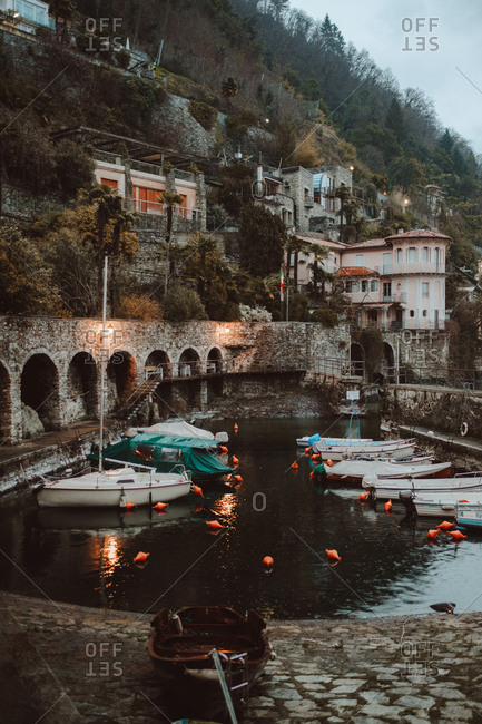 Small motor boats anchored in the channel of small town in mountains.
