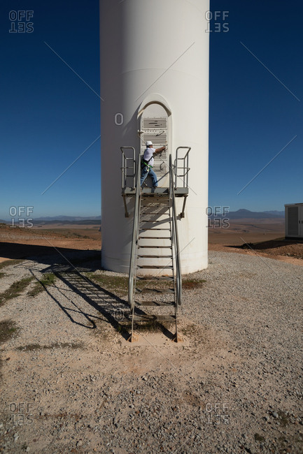 Engineer shutting the door of a wind mill entrance
