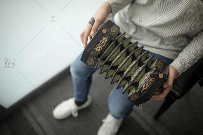 Low section of schoolgirl playing accordion in music school